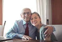 an elderly man and a young woman posing for a photo